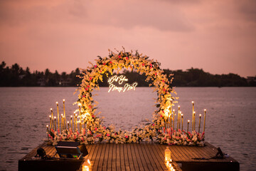 Night landscape view of will you marry me lights on a riverside pathway with flower decorations 