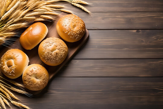 Wheat and buns on a wooden background with a blank for copy space design.