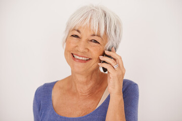 Senior woman, phone call and smile in studio portrait for conversation, chat and fashion by...
