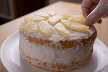 The cake is decorated with slices of pear. Making cakes.