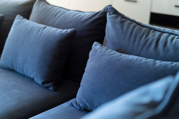 Selective focus on blue soft pillows neatly folded on sofa after general cleaning