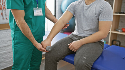 Obraz premium Man undergoing rehabilitation with therapist assisting in physiotherapy clinic