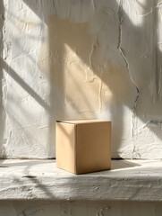 A wooden box rests on a window sill against a white wall