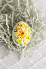 The symbol of Easter - painted egg with colorful handmade spring flowers