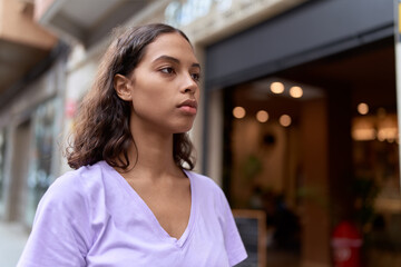 Young african american woman looking to the side with serious expression at street