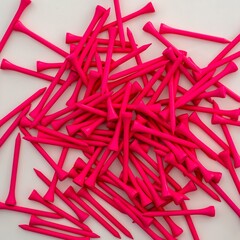A pile of neon pink 70mm wood golf tees lying on a flat white surface.