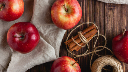 Red apples on a wooden background with cinnamon