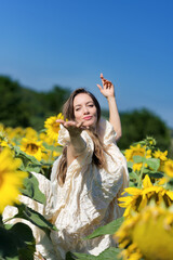 beautiful brunette young woman in a sunflower field, Dancing wrapped in a white cloth