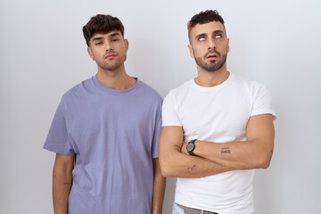 Homosexual gay couple standing over white background looking sleepy and tired, exhausted for...