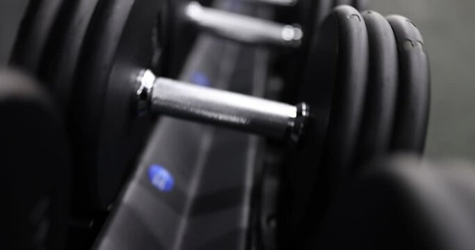Lot of dumbbells lying neatly in row in gym closeup 4k movie slow motion. Sports training concept