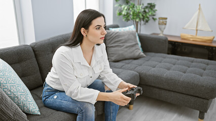 Focused hispanic woman playing video game in cozy living room interior.