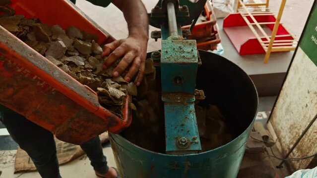 Worker using machinery to crush organic seeds for to extract oil in the mill