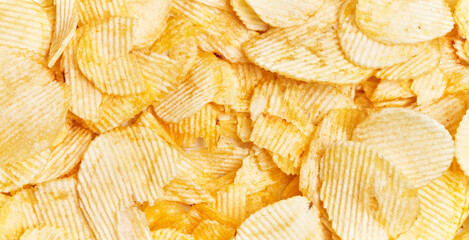 Close-up view of abundant crispy potato chips filling the frame for a textured background - obrazy, fototapety, plakaty