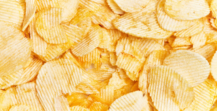 Close-up view of abundant crispy potato chips filling the frame for a textured background