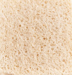 Close-up texture of a piece of white bread, emphasizing its porous surface and airy crumb for culinary contexts.