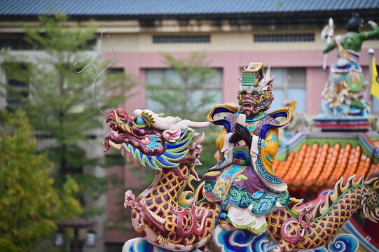 Taiwan - Jan 23, 2024: The photo shows a close-up of a detail on the roof of Songshan Ciyou Temple in Taipei, Taiwan. The detail shows a man with a dragon-like face riding on a dragon.