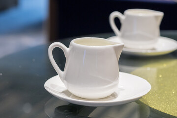 Cup of pouring cream on the table in the cafe