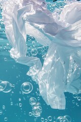 Glistening bubbles and a white shirt flowing in clear blue water symbolizing clean laundry