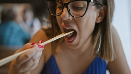 At a modern restaurant, a beautiful hispanic woman in glasses relishes her gourmet beef meal,...