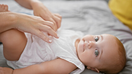 Lovely mother and daughter share a moment, touching and tickling on bedroom bed, expressing love and bond indoors at home