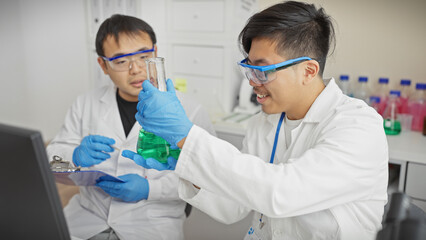 Two men in lab coats examining chemical flasks in a laboratory setting.