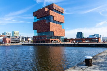 Antwerp, Belgium. 15 April 2023. Museum aan de Stroom MAS Striking, red, sandstone museum with...