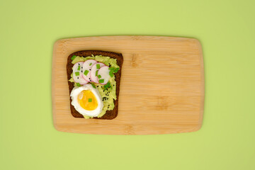 Rye bread sandwiche with avocado, egg, radish, greenery and black cumin seeds and copy space. Healthy eating concept.