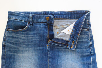 Blue jean skirt in front view on white background, closed-up studio shot.