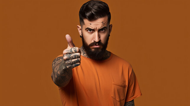 Young hispanic man with beard and tattoos drinking a cup of coffee pointing with finger up and angry expression, showing no gesture