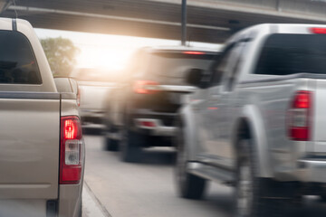 Rear side view of pickup car driving on the road. Other cars driving pass fast speed on the road. During traffic struck in Thailand. Background with concrete bridge with light under from the sky. © thongchainak