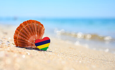 Sandy beach in Mauritius. Mauritius flag in the shape of a heart and a large shell. A wonderful...