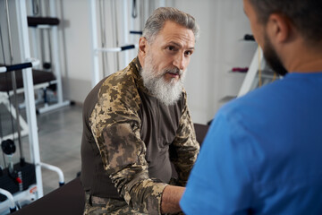 Doctor communicates with a military man in a rehabilitation center