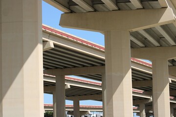 From the ground looking up three tiers of a busy turnpike, the sign appears to be more sky...