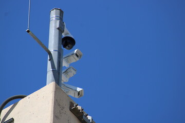 Close up of traffic cams high above the roadway of a major turnpike.