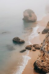 Algarve's Serene Beach: An Elevated Glimpse Amidst Mist, Calm Seas, and Rocks in a Professional Beige Aesthetic.