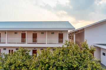 Simple two-story modest hotel on a tropical island with many rooms.