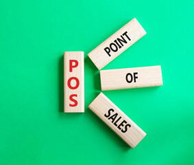 POS - Point Of Sales symbol. Wooden cubes with words POS. Beautiful green background. Business and POS concept. Copy space.