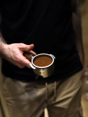 barista sosteniendo un  filtro de café con café molido
