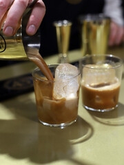 barman sirviendo cocteles de crema de café con hielo