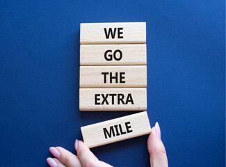 We go the extra mile symbol. Wooden blocks with words We go the extra mile. Beautiful deep blue...
