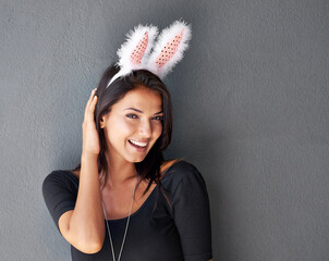 Bunny ears, space or portrait of happy woman with fashion or style isolated on grey background. Model laughing, confident or casual female person in studio with smile, easter holiday or mock up