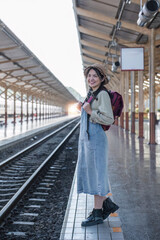 Young Asian woman in modern train station Female backpacker passenger waiting for train at train station to go on holiday.