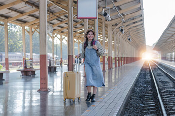 Young Asian woman in modern train station Female backpacker passenger waiting for train at train...