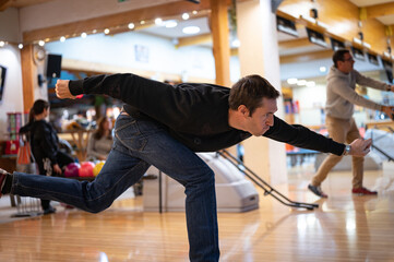 Side view of the effort face and throwing technique of the bowling ball. on a young player dressed in black