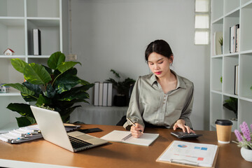 Business finance concept, Business woman using calculator to calculate business data at office