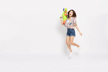 Young Asian woman in summer outfits jumping and holding water guns plastic for Songkran festival in Thailand isolated on white background - 756579700