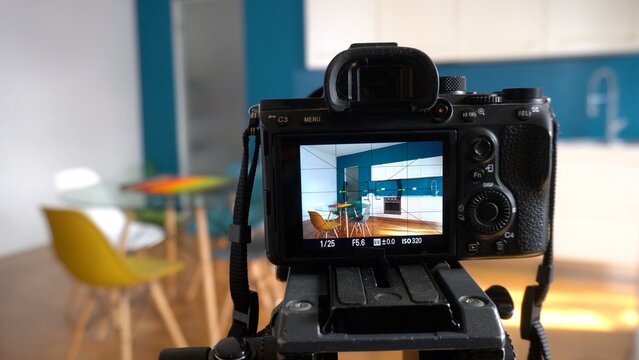 Real estate photographer taking pictures and videos  at house  in apartment living room with professional camera - selling home with real estate agency and home staging indoor home design 