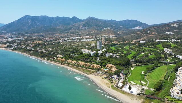 Aerial view of the city, beach, golf course and mountain.