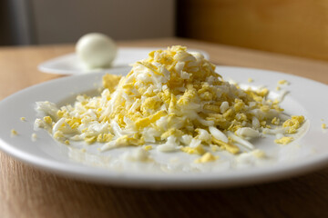 Grate the boiled egg on a plate.