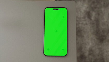 Smartphone place on coffee table, Green screen cellphone, Close up display mobile phone with mock up, Chroma key monitor